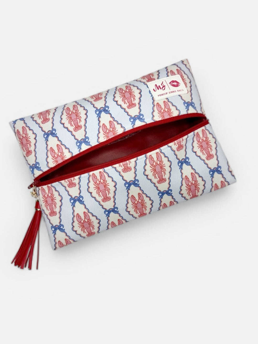 Makeup Junkie Bags large flat zip clutch in pink and blue lobster print open to reveal red interior lining with red zipper and red tassel on white background