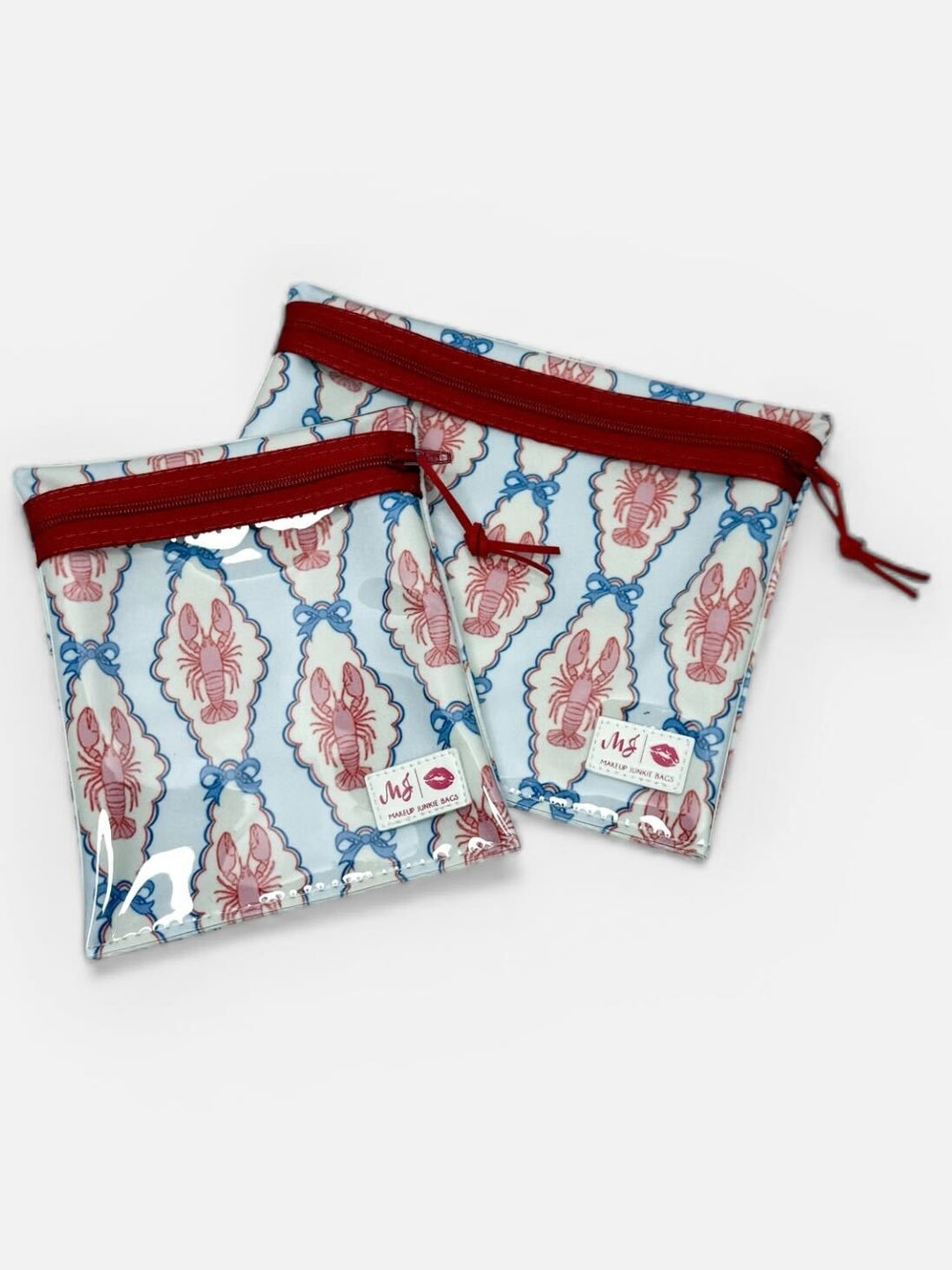 Makeup Junkie Bags set of two clear zip pouches in pink and blue lobster print with red zippers on white background