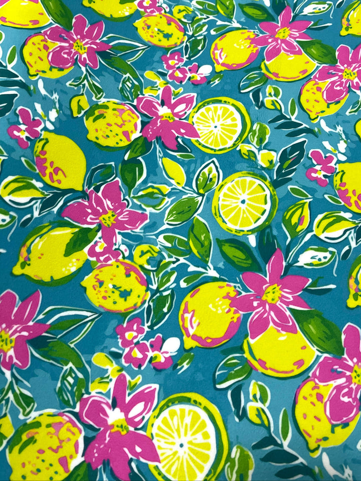 Teal lemon and floral print fabric with yellow lemons, pink flowers, and green leaves on teal background used for Makeup Junkie Bags