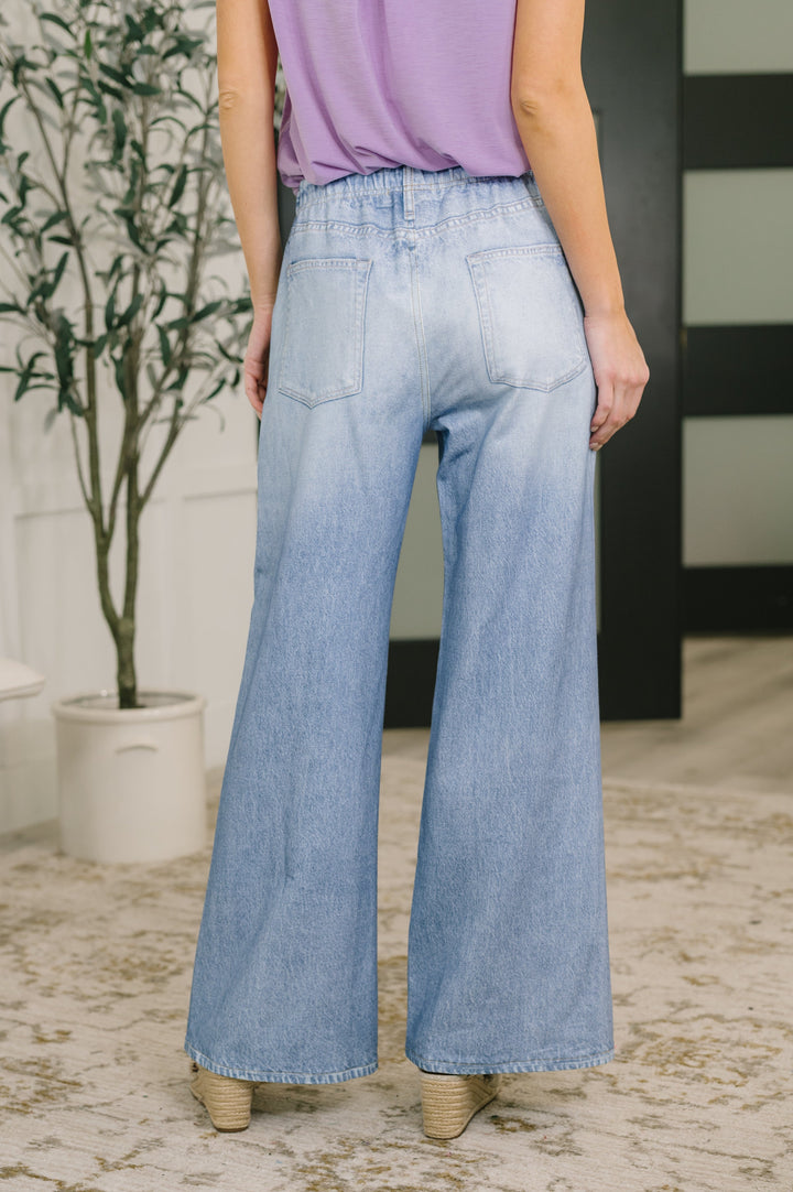 Back view — light wash wide-leg paperbag jeans showing large back patch pockets
