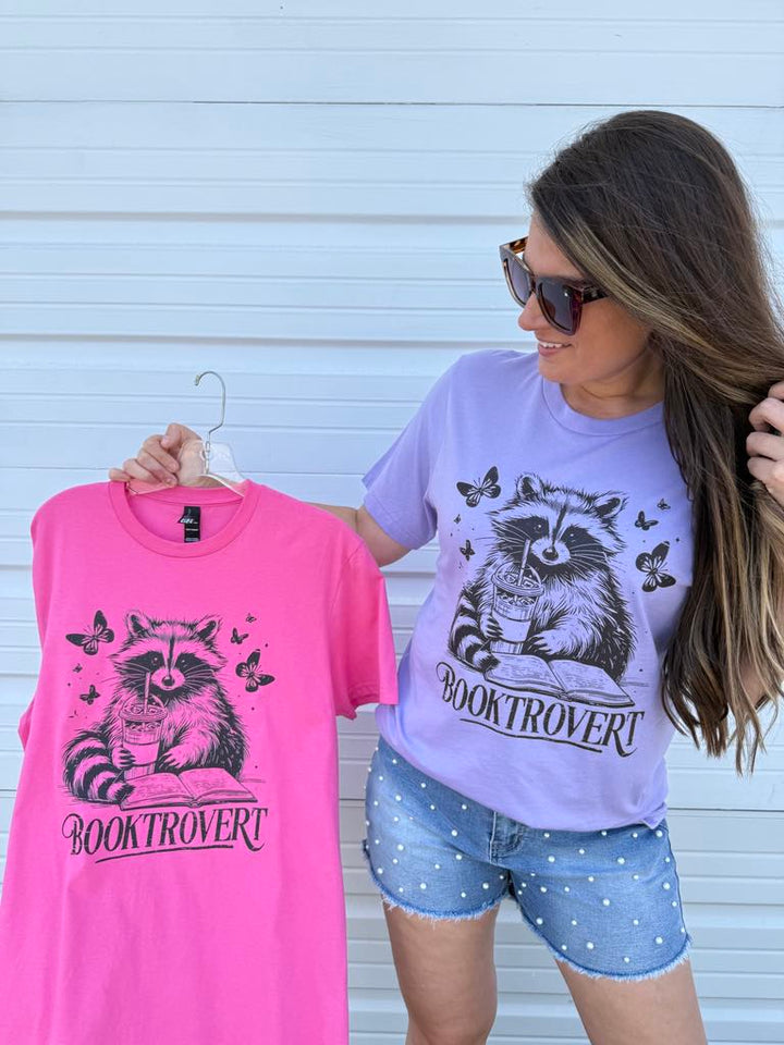 by PrepO: Booktrovert Reading Raccoon Short Sleeve Graphic Tee (Ships in 1-2 Weeks)