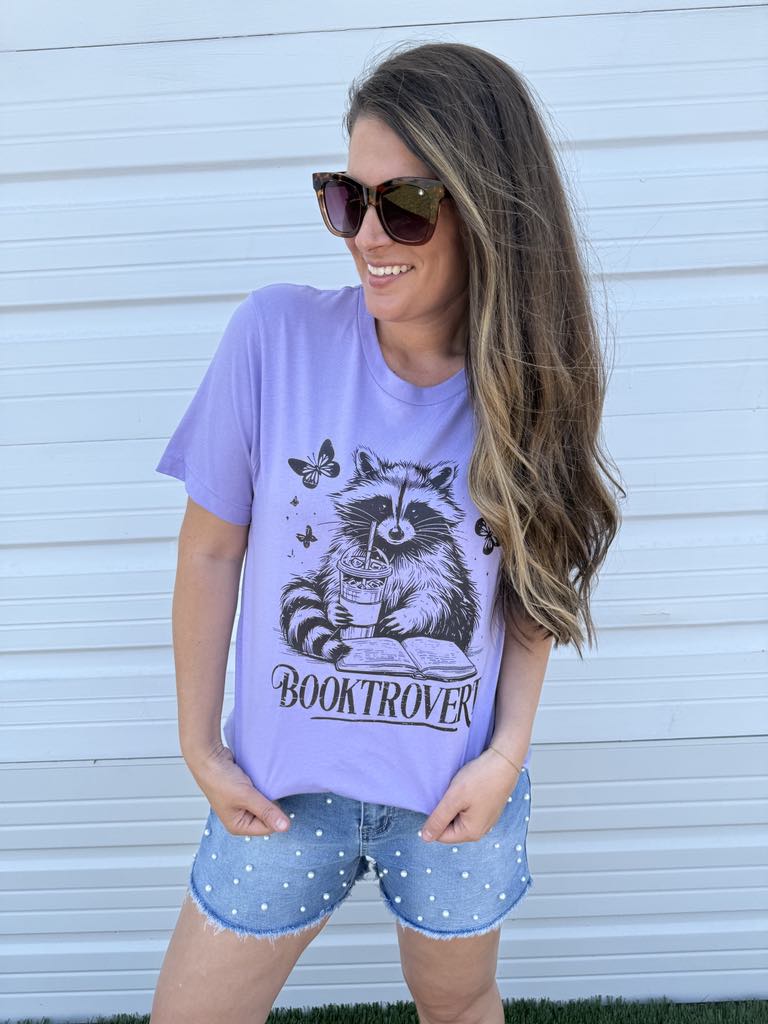 by PrepO: Booktrovert Reading Raccoon Short Sleeve Graphic Tee (Ships in 1-2 Weeks)