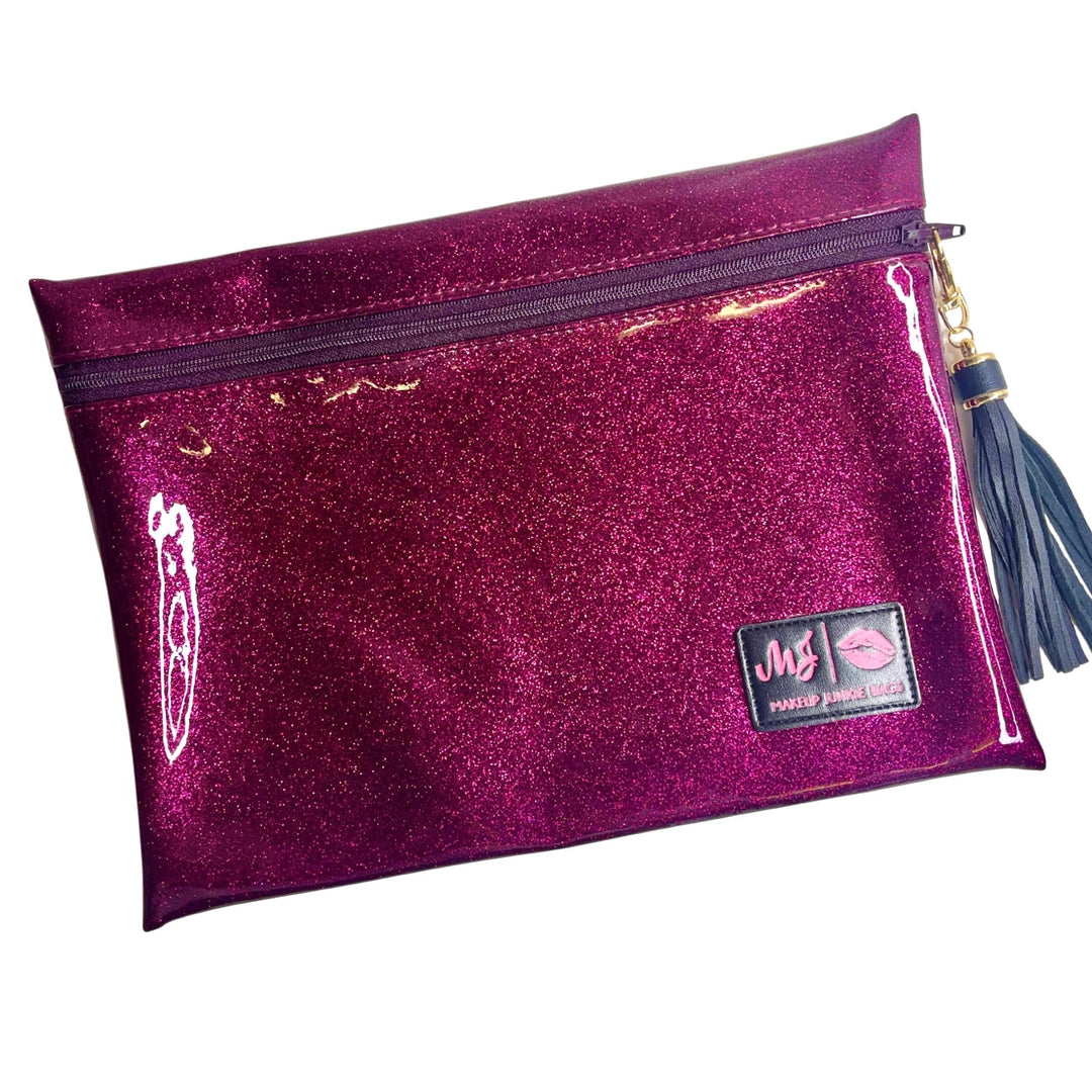 Makeup Junkie Bags magenta hot pink glitter medium zip makeup bag with navy tassel zipper pull and branded patch, front view on white background