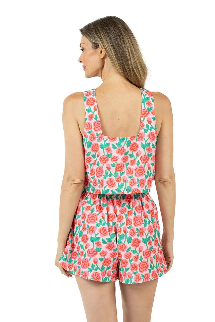 Back view of woman in a pink rose print square-neck sleeveless crop top and matching elastic-waist shorts, showing the open back detail.