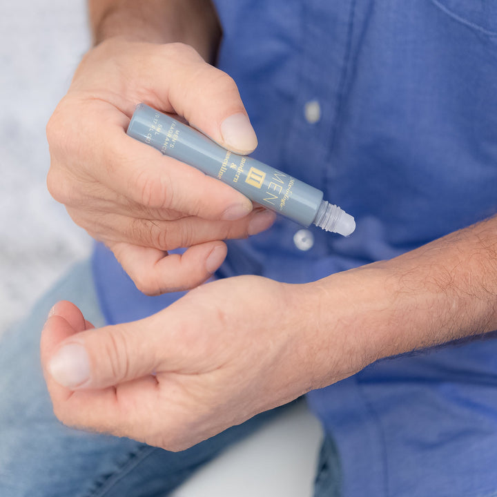 Mixologie Men's Fragrance II Modern & Masculine, 5 ml rollerball, being applied to wrist by man in blue button-down shirt