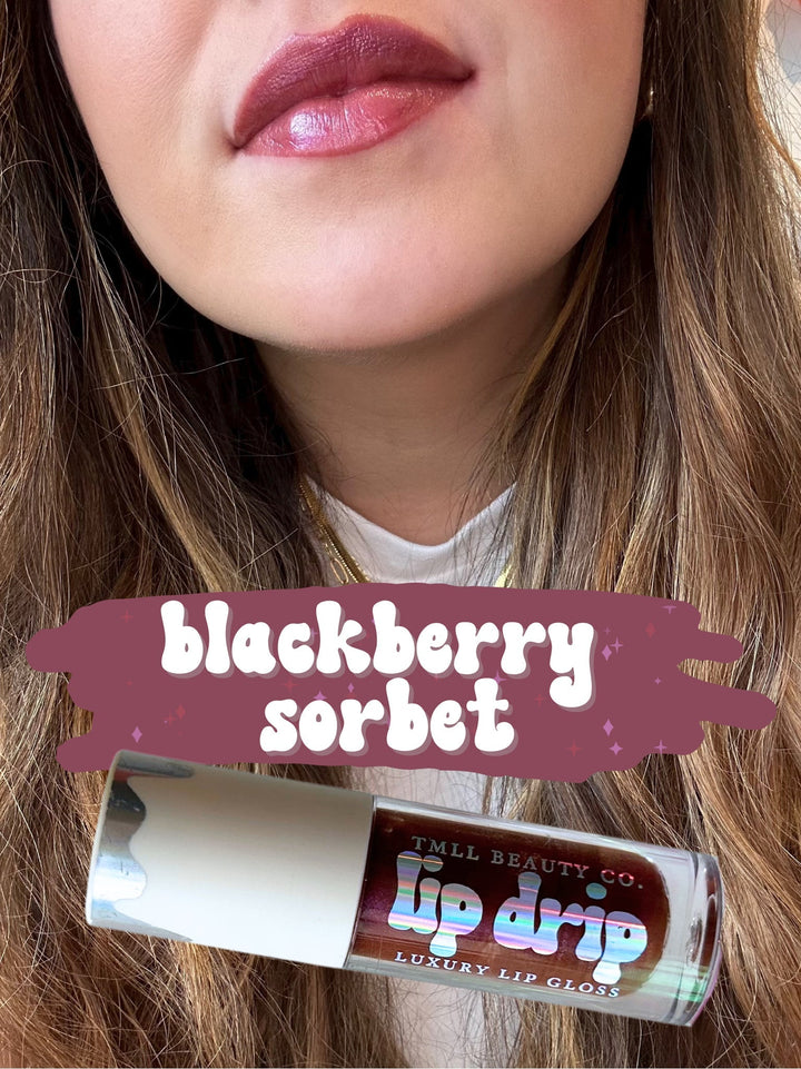 TMLL Beauty Co. Lip Drip Luxury Lip Gloss in Blackberry Sorbet — a deep berry-brown shade shown on lips with holographic tube below