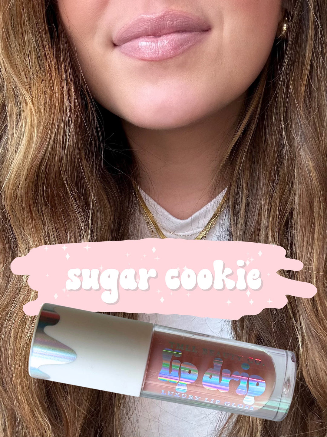 TMLL Beauty Co. Lip Drip Luxury Lip Gloss in Sugar Cookie — a sheer nude-pink shade shown on lips with holographic tube below