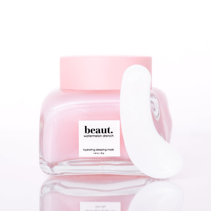 Beaut Watermelon Drench Hydrating Sleeping Mask 50g open glass jar with white spatula leaning against jar on white reflective surface