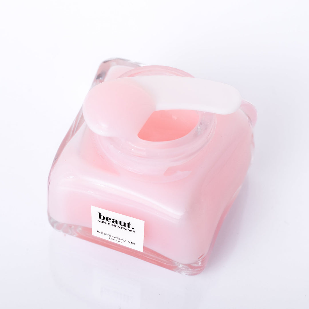 Beaut Watermelon Drench Hydrating Sleeping Mask 50g open glass jar shot from above showing pink cream texture with spatula on white background