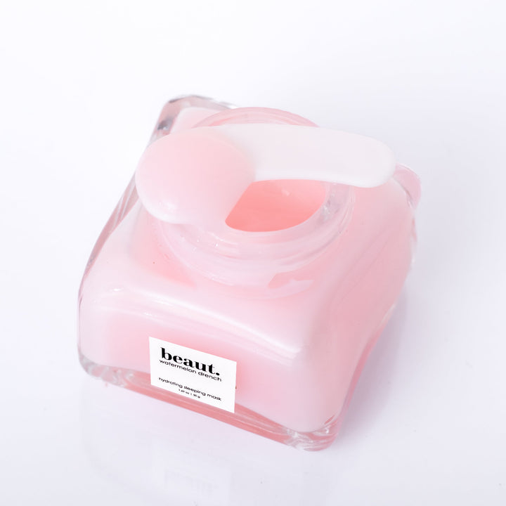 Beaut Watermelon Drench Hydrating Sleeping Mask 50g open glass jar shot from above showing pink cream texture with spatula on white background